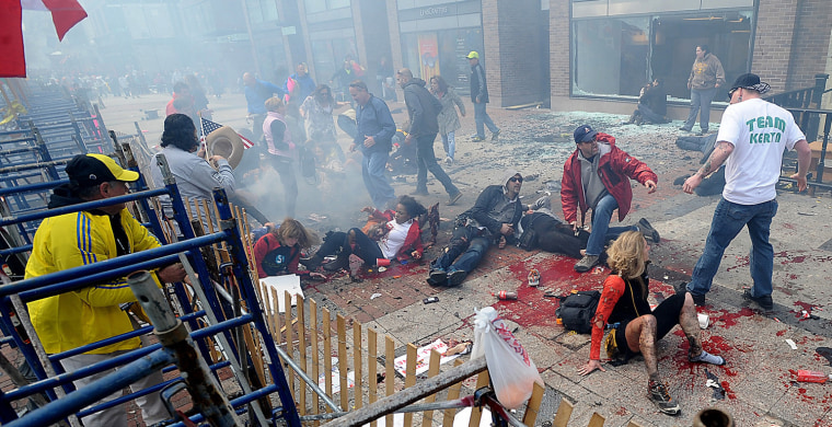 Image: Wounded spectators lie injured following an explosion at the Boston Marathon